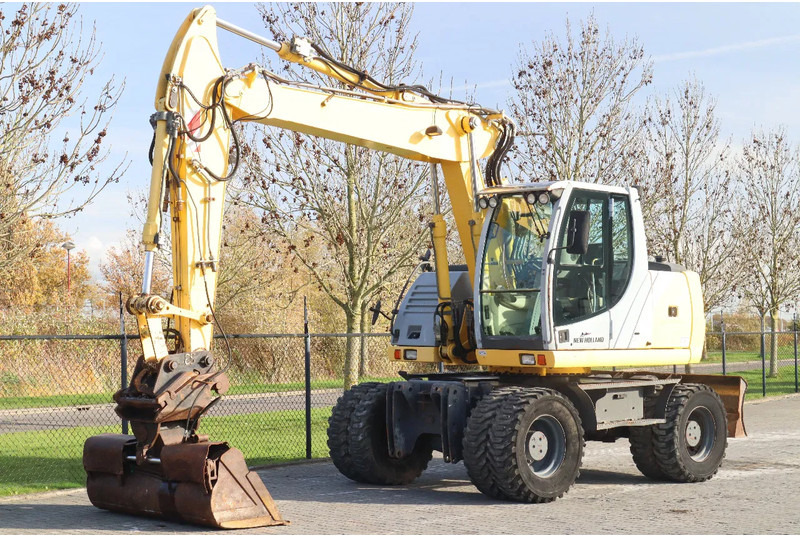 New Holland MH CITY | TILT BUCKET | QUICK COUPLER | DOZER BLADE - Riteņu ekskavators: foto 2 New Holland MH CITY | TILT BUCKET | QUICK COUPLER | DOZER BLADE - Riteņu ekskavators: foto 2