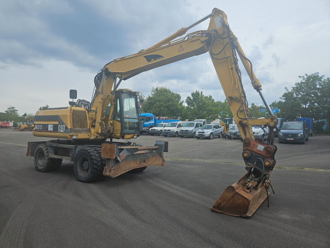 CAT M315 Mobilbagger mit Pratzen und Schild - Riteņu ekskavators: foto 4 CAT M315 Mobilbagger mit Pratzen und Schild - Riteņu ekskavators: foto 4