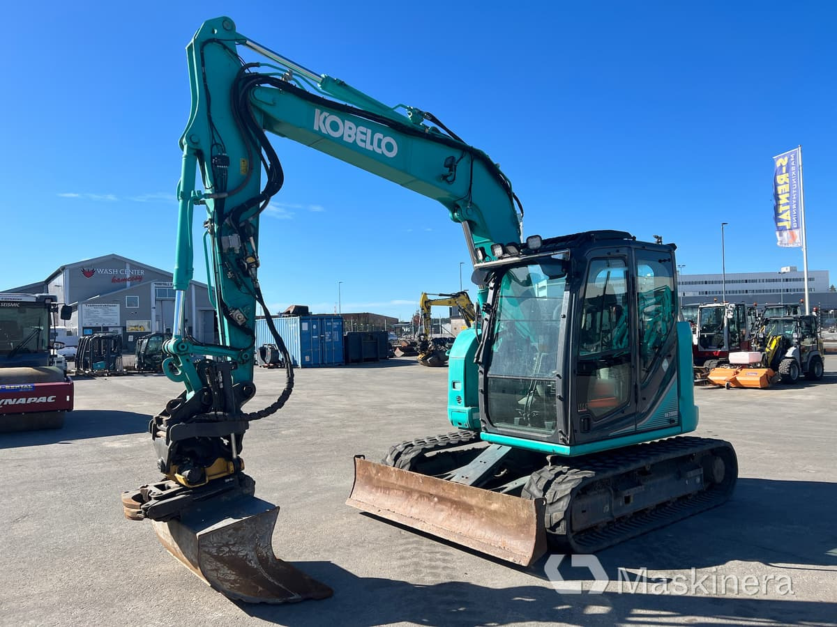 Grävmaskin Kobelco SK75SR-3E - Kāpurķēžu ekskavators: foto 1 Grävmaskin Kobelco SK75SR-3E - Kāpurķēžu ekskavators: foto 1