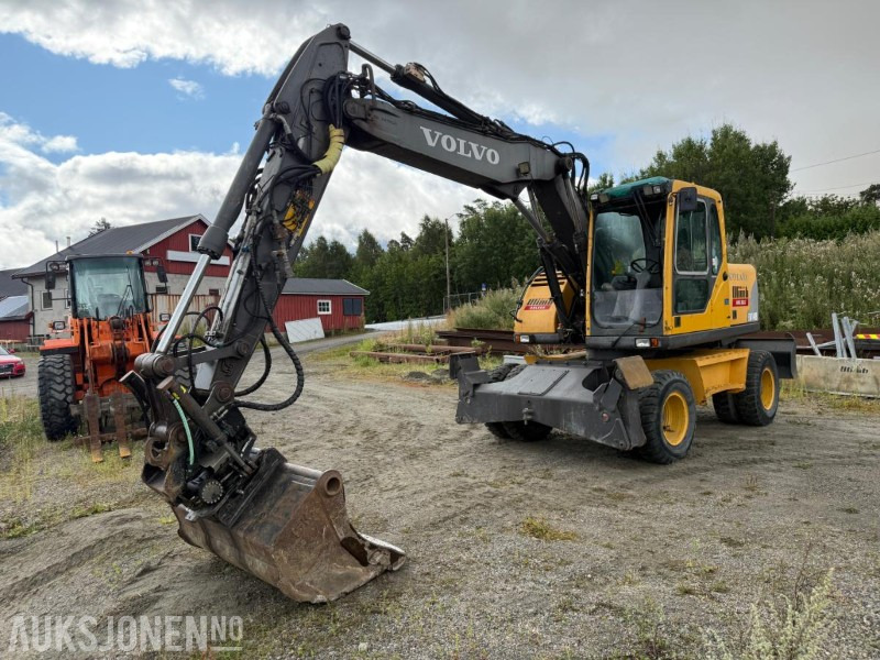2006 Volvo EW140B Hjulgraver m/pallegaffel og skuff - Steelwrist tiltrotator. - Ekskavators: foto 1 2006 Volvo EW140B Hjulgraver m/pallegaffel og skuff - Steelwrist tiltrotator. - Ekskavators: foto 1