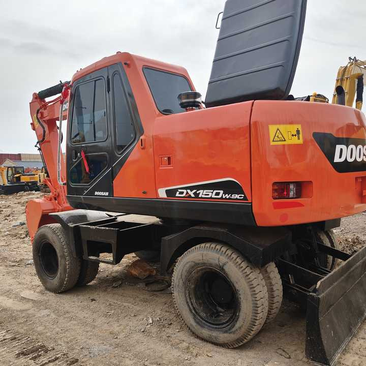 Used Original Doosan Dx150w-9 Wheel Excavator for Sale - Riteņu ekskavators: foto 1 Used Original Doosan Dx150w-9 Wheel Excavator for Sale - Riteņu ekskavators: foto 1